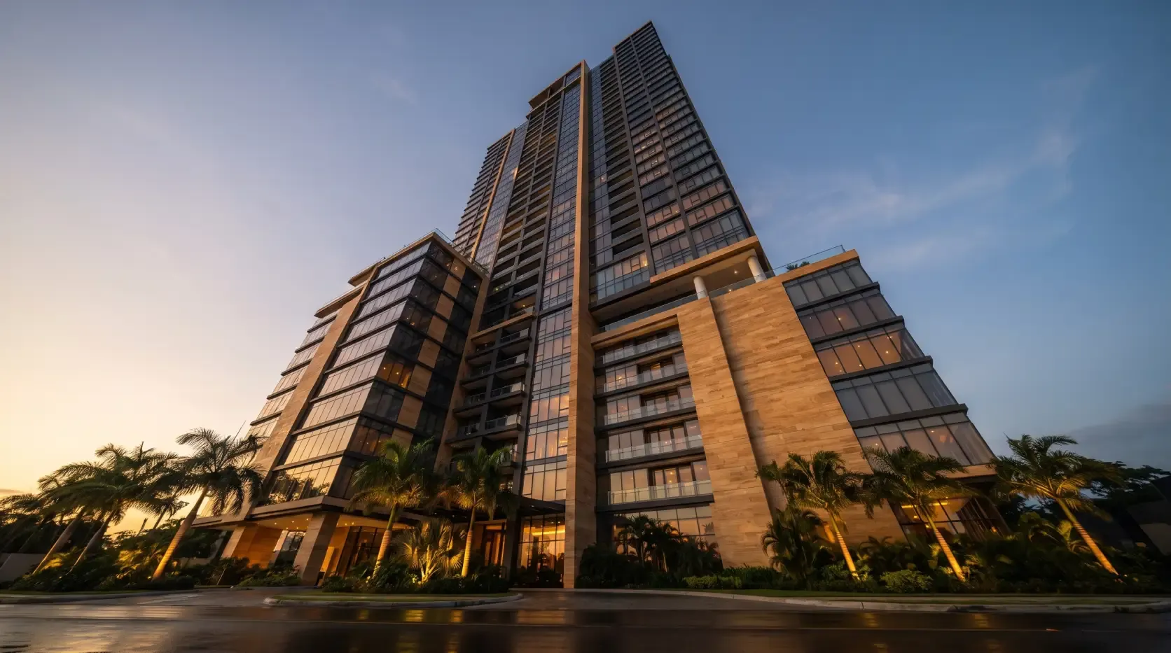 Torre residencial de lujo al atardecer en Panamá, con fachada de vidrio y madera y palmeras en la entrada