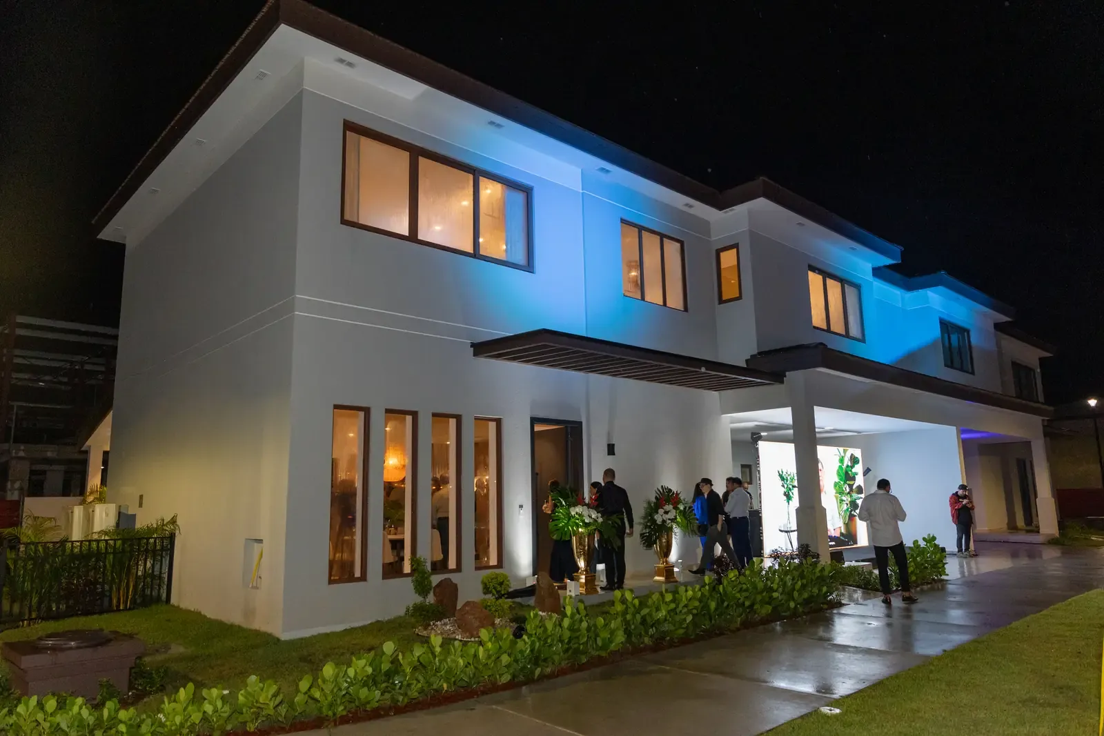 Fachada iluminada de noche de una casa en The Woods, Santa María